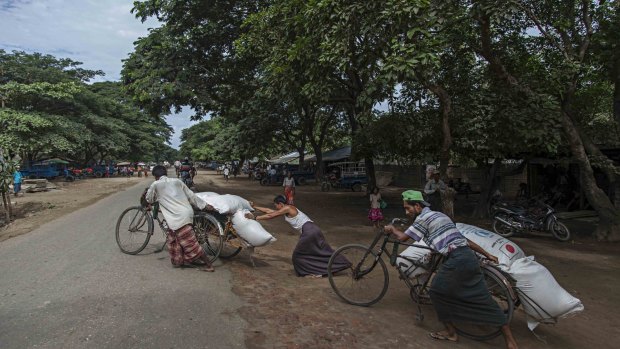 Rohingya men prepare to deliver rice donations from the World Food Program in Sittwe in May.