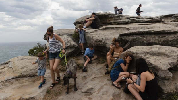 People take cover at Bondi after winds whipped up sand and dust.