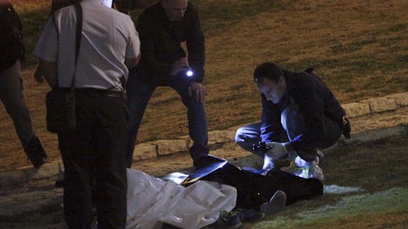 Israeli police examine the body of a Palestinian in Jerusalem on Sunday. 