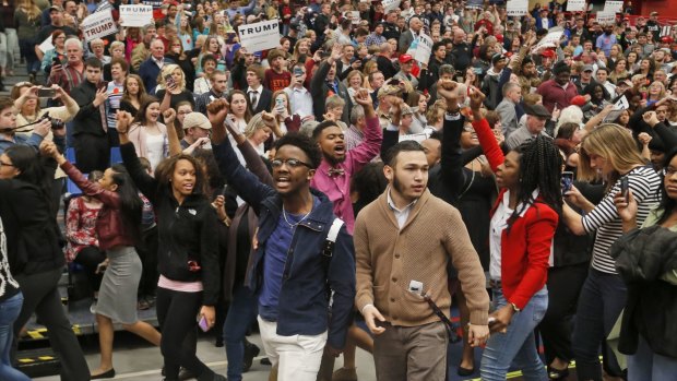 Protesters are escorted out of the rally at Radford University.