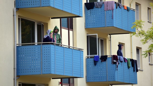 Refugees stand on the balconies of a repatriation facility for migrants from the Balkan States in Bamberg, Germany. Refugees who arrive here are not necessarily expected to remain in Germany.