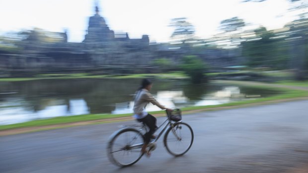 A local woman on her way past Angkor Wat.