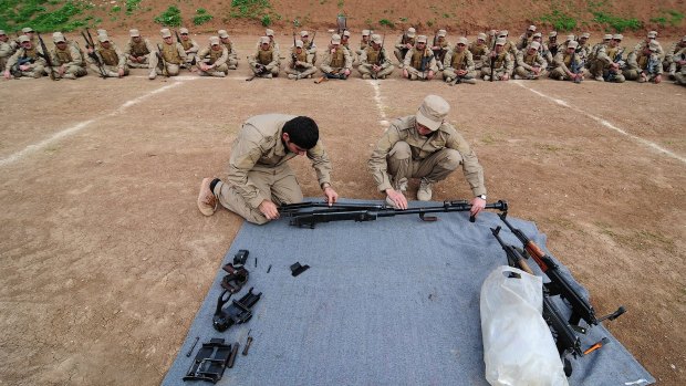 Two YPG fighters teach new conscripts to Rojava's new army how to dismantle and reassemble a heavy machine gun known as a dushka. 