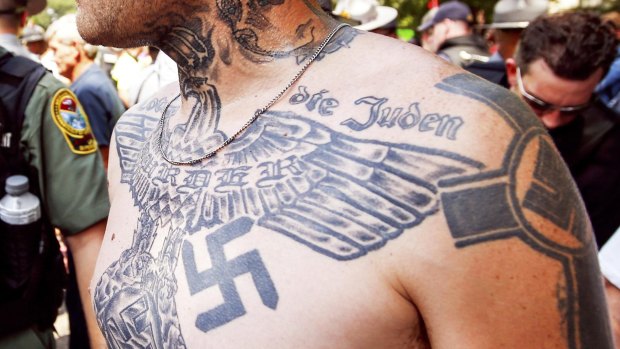 A supporter of the Ku Klux Klan adorned with a swastika tattoo at the rally.  