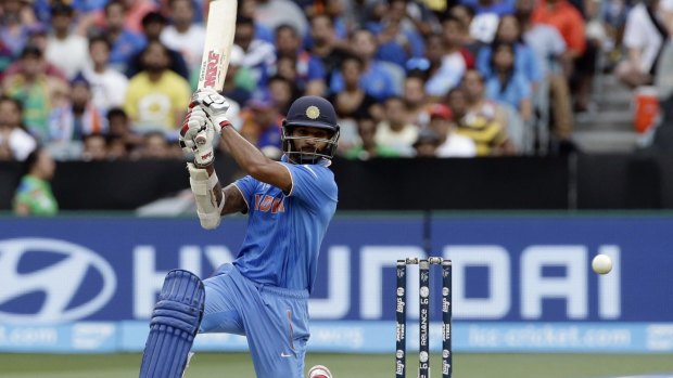 Shikhar Dhawan goes down on one knee to drive through the covers.