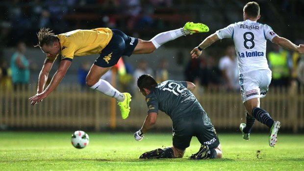 Sent sprawling: Central Coast's Zac Anderson tumbles over keeper Liam Reddy in the Mariners' heavy defeat to the Victory.