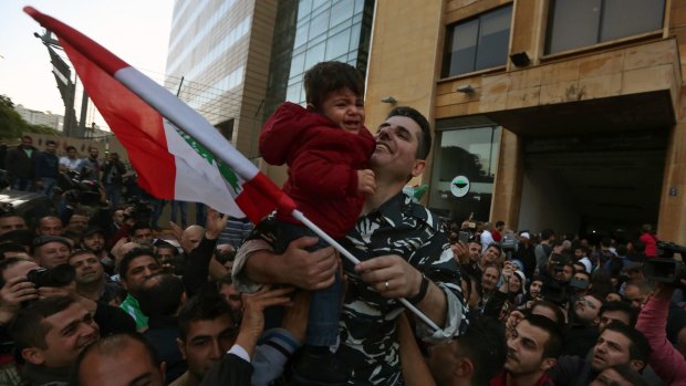 Lebanese policeman Abbas Msheik  is carried on his friends' shoulders as he holds his son Mohammed during a celebration of his release from captivity in Beirut.