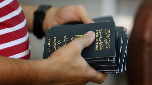 An employee delivers new passports at the main Baghdad passport office, which has had a marked increase in the number of requests for travel documents.