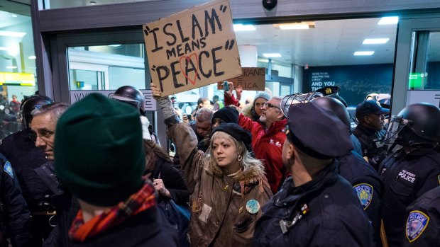 Protesters are surrounded by police officers at John F. Kennedy International Airport in New York.