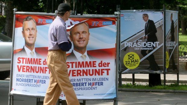 A man walks past election posters of Alexander van der Bellen, candidate for the presidential elections and former head of the Austrian Greens.