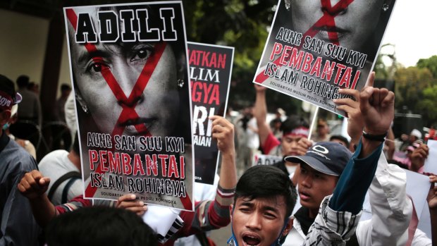 Protesters hold a defaced poster of Aung San Suu Kyi during a rally demanding justice for Rohingyas outside Myanmar's embassy in Jakarta in November.