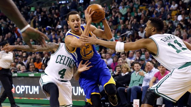 Offensive dynamo: Golden State Warriors guard Stephen Curry tries to get between Boston Celtics defenders Evan Turner and Isaiah Thomas.