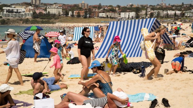 A woman stumbles on a long guy rope on a crowded Bondi Beach in Sydney