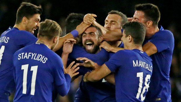 Giannis Maniatis of Greece is congratulated by his teammates after kicking a goal from half way.