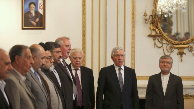 Iran's Deputy Foreign Minister, Mehdi Danesh Yazdi (right), stands with former British foreign secretary Jack Straw, former British chancellor Norman Lamont (third from right) and other guests during the playing of the British national anthem in London.