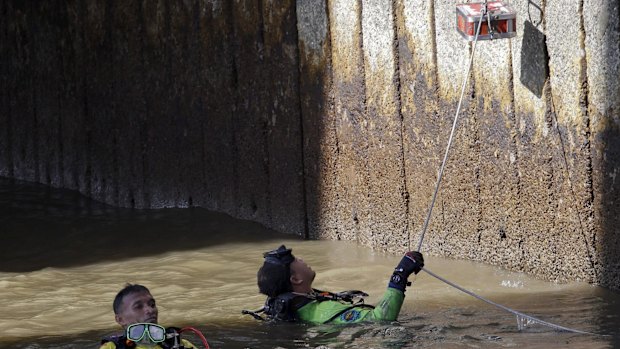 Divers recover pieces of evidence at Sathorn pier in central Bangkok.