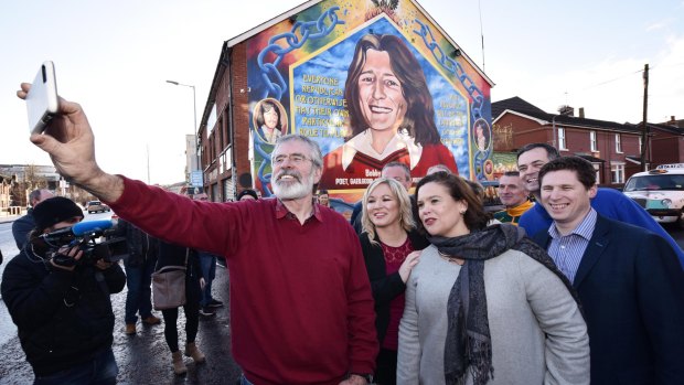 Sinn Fein president Gerry Adams takes a selfie with southern leader Mary Lou McDonald, centre, and northern leader Michelle O'Neill in Belfast.
