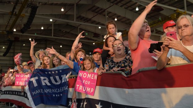 People wait for the arrival of President Donald Trump at his "Make America Great Again Rally" at Orlando-Melbourne International Airport in Melbourne, Florida. 