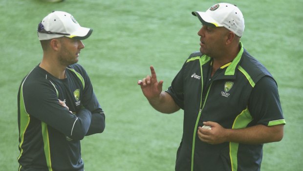 Stuck indoors: Michael Clarke and Darren Lehmann speak during the Australian nets session at the National Cricket Centre in Brisbane.
