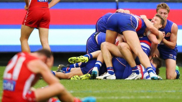 The pain that haunts: Bulldogs players celebrate their 2016 grand final win while Sydney players hurt. 
