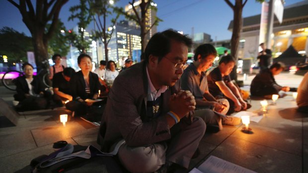 People pray during a service for peace on the Korean Peninsula near the US Embassy in Seoul, South Korea, on Thursday.