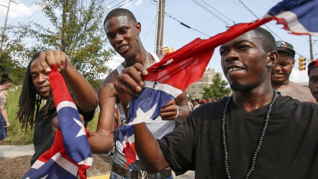 Anti-Klan protesters  tear apart a Confederate flag in Columbia, South Carolina.