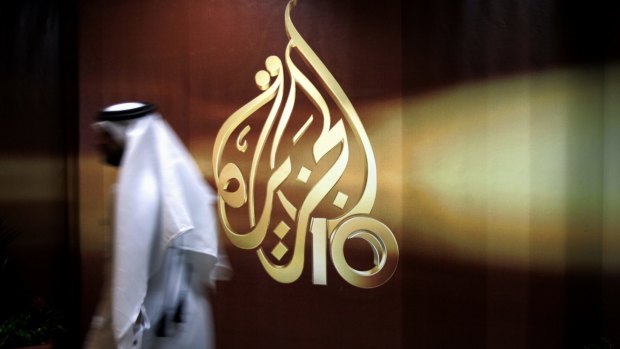 An employee walks past the logo of Al Jazeera in Doha. Among the 13 demands is the closure of the Qatar-funded network.