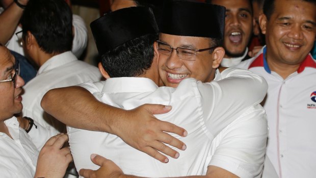 Jakarta's governor-elect Anies Baswedan, right, hugs his running mate  as unofficial results showed him defeating Ahok on April 19.