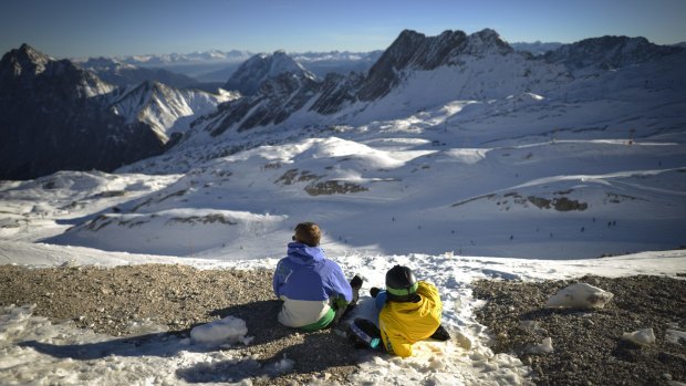 Skiers rest on a grassy patch near Garmisch-Partenkirchen, Germany on Monday.