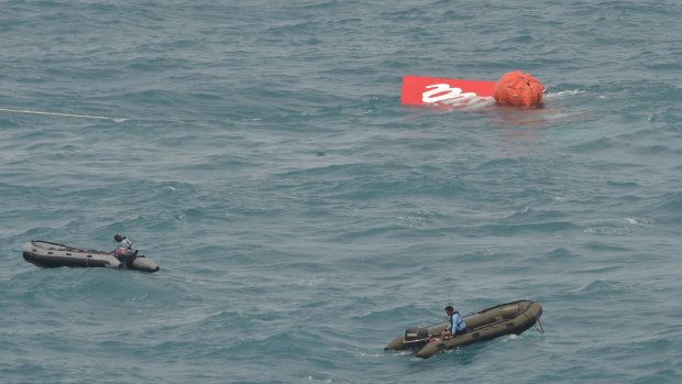 Part of the tail of AirAsia flight QZ8501 floats on the water's surface on Saturday. 