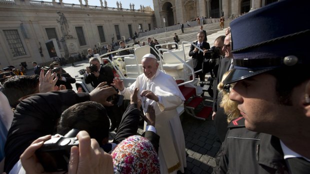 Pope Francis salutes as he leaves after his weekly general audience in St Peter's Square at the Vatican on Wednesday. 