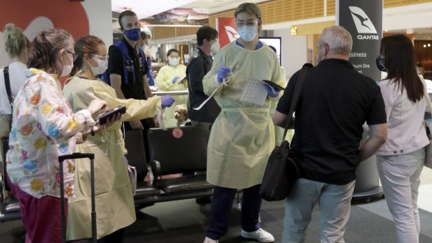 Health workers screen passengers arriving from Melbourne at Sydney Airport.