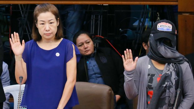 Choi Kyung-jin and her former househelp Marissa Morquicho take their oaths at the start of the Philippine Senate probe into Jee Ick-joo's murder, in which police stand accused.