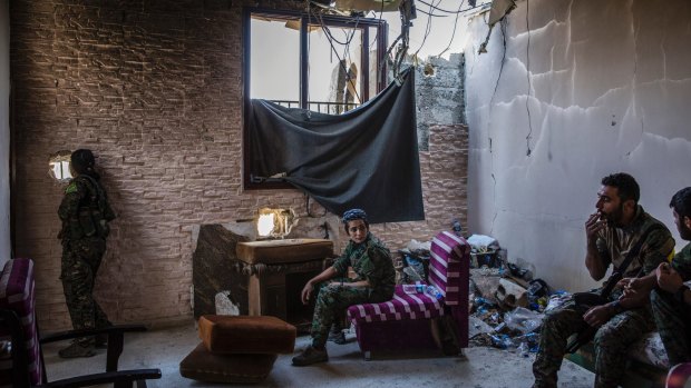 Syrian Democratic Forces fighters use a destroyed building as a base in western Raqqa.