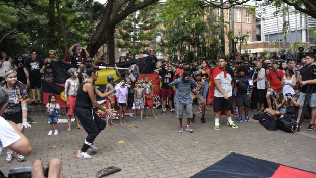 Brisbane's Invasion Day protest ended with a dance performance and the lowering of the Aboriginal flag from the posts outside state parliament.