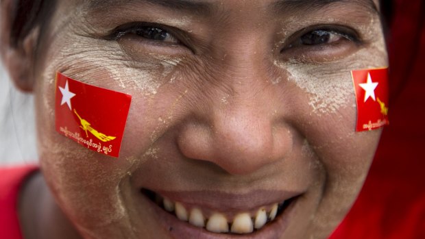 A member of Myanmar opposition leader Aung San Suu Kyi's National League for Democracy party smiles as she rides a trishaw during an election rally on Tuesday.