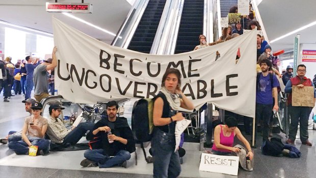 Demonstrators block an escalator at the international terminal as protests countries continue at San Francisco International Airport.