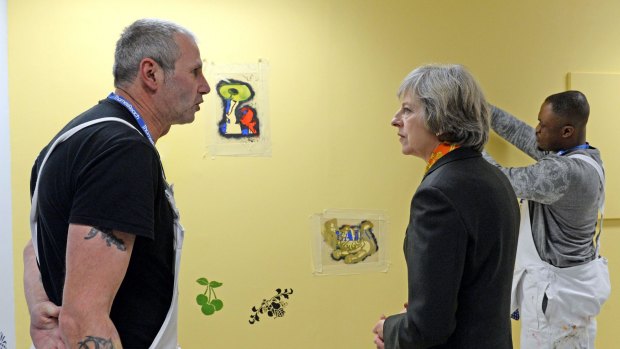 Britain's Prime Minister Theresa May talks to Peter Cheasman during a visit to Thames Reach Employment Academy Centre, in southeast London.