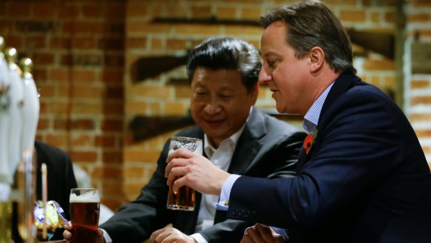 David Cameron, right, drinks a pint of beer with Chinese President Xi Jinping, at The Plough pub in Casden, England in 2015.