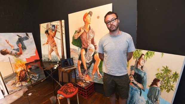 Artist Fintan Magee with some of his work from his Water World exhibition inspired by the Brisbane floods. 