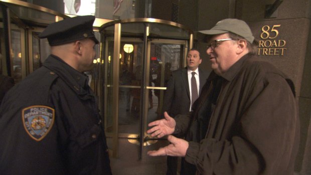 A scene from Michael Moore's 2009 film <em>Capitalism: A Love Story</em> showing the director confronted by a policeman.