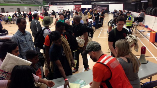 Evacuees from Fort McMurray  line up to register at an evacuation centre in Anzac, Alberta, Canada .
