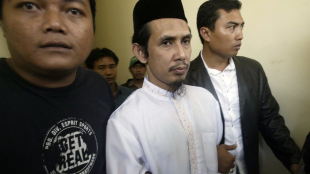 Self-described military commander of the south-east Asian terror network Jemaah Islamiyah Abu Dujana, centre, is escorted by police officers before his trial in Jakarta in 2007.