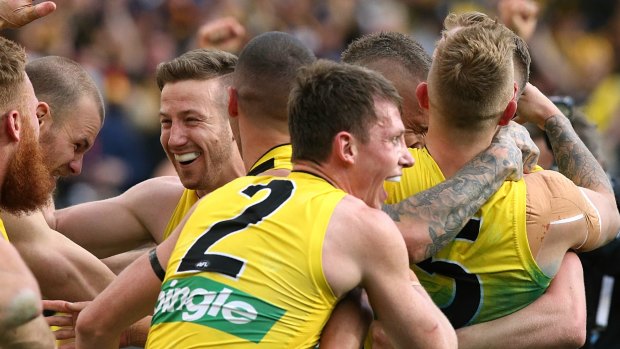 Dylan Grimes (No.2) embraces his teammates after the siren in the 2017 AFL grand final.