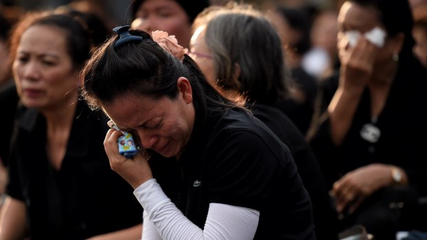 Women dressed in black weep outside the Grand Palace in Bangkok.