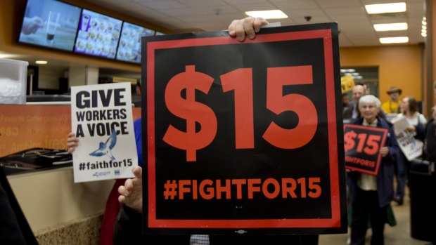 Striking workers walk through a Dunkin' Donuts store during a rally in Albany, NY, on Tuesday.