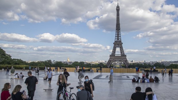 People stroll around Trocadero Square near the Eiffel Tower as lockdown restrictions lift.