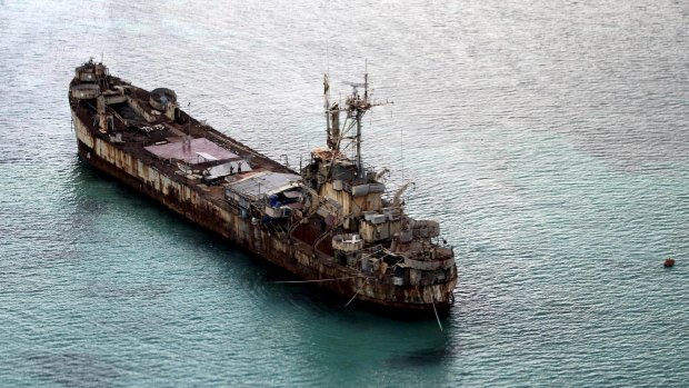 Filipino soldiers wave from the dilapidated Sierra Madre ship of the Philippines Navy as it is anchored near Ayungin shoal (Second Thomas Shoal) in the Spratly group of islands in the South China Sea, west of Palawan, Philippines, in this photo taken in May.