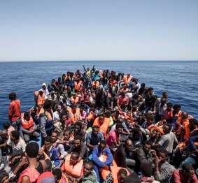Migrants crowd the deck of their wooden boat off the coast of Libya May 14, 2015.