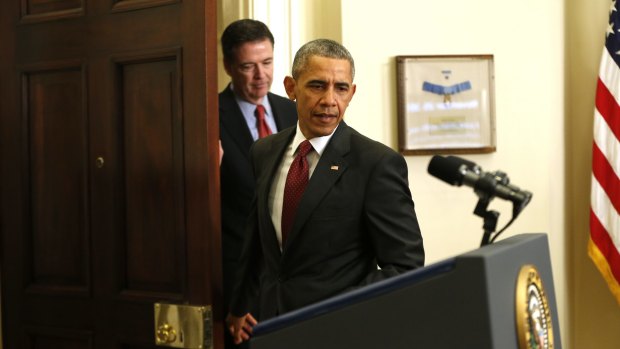 President Barack Obama, followed by FBI Director James Comey, arrives in the Roosevelt Room of the White House in 2015. 